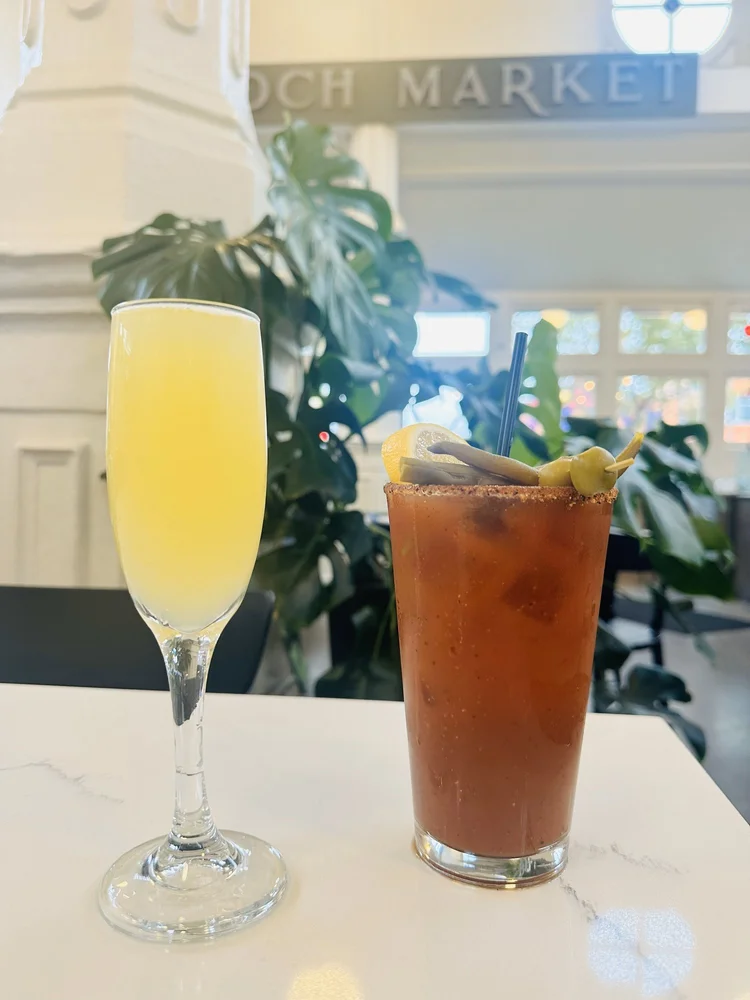 Mimosa and Bloody Mary brunch cocktails at St. Roch Market with cast iron columns in background