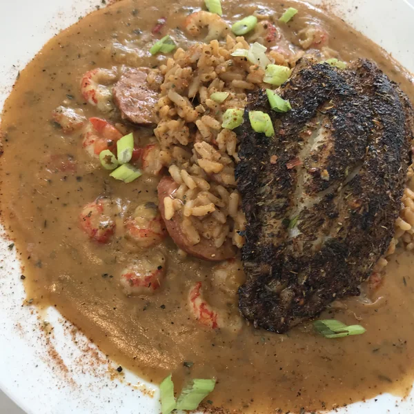 Blackened Catfish Louisiana at Chef Charles Bistreaux: a blackened catfish fillet over jambalaya, topped with crawfish étouffée at St. Roch Market