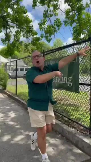 Kevin Pedeaux pointing at the St. Roch Market parking sign on St. Claude Avenue