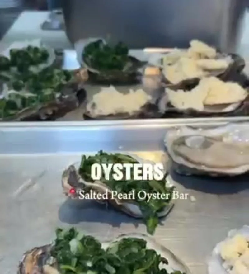 Oysters Rockefeller at Salted Pearl Oyster Bar inside St. Roch Market topped with spinach and cheese