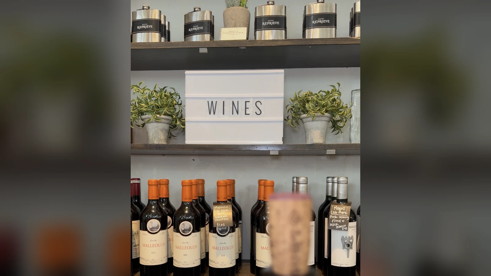 The illuminated WINES sign above Emilio Moro Malleolus bottles at Roch's Reprieve inside St. Roch Market
